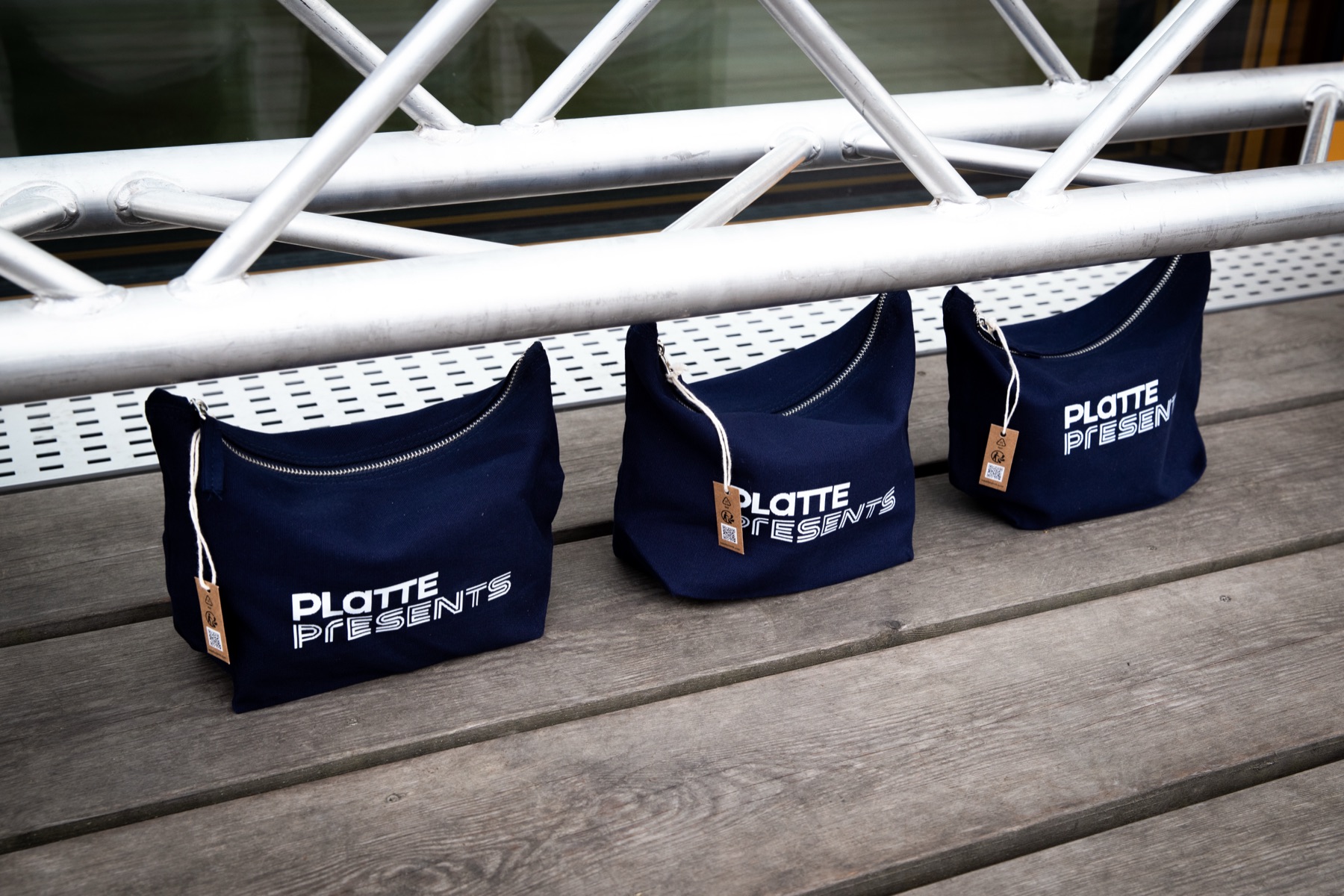 Aluminium truss seating with navy PLATTE PRESENTS bags set out for guests